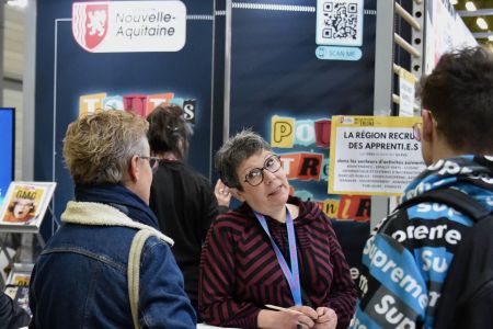Jeune femme devant un TER Nouvelle-Aquitaine sur un quai de gare